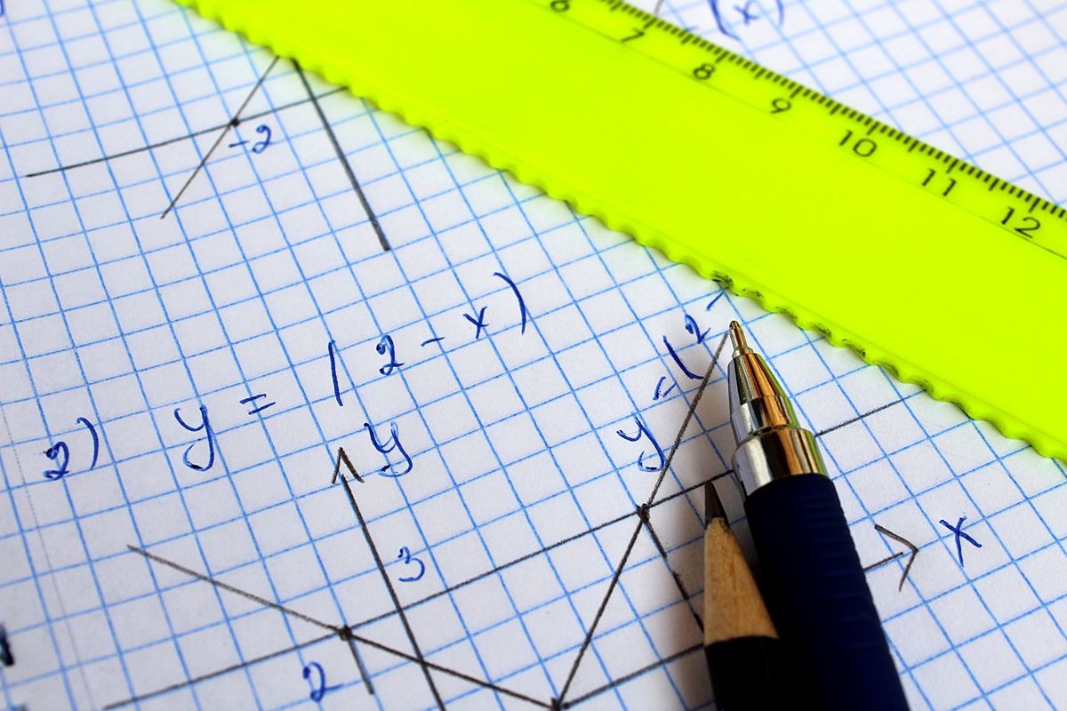 notebook with a mathematical term with a pen and pencil